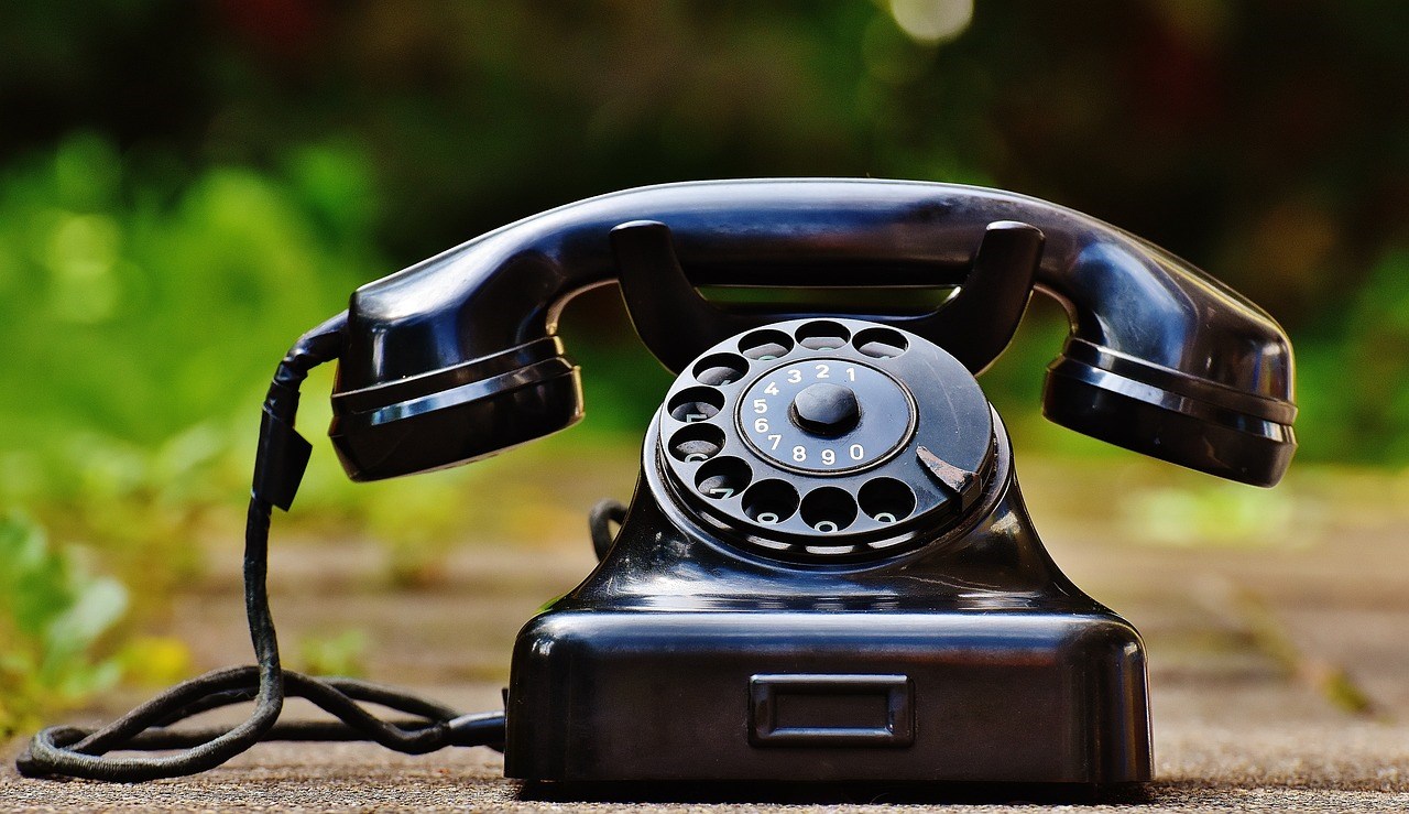 Svart, gammal telefon med snurrplatta