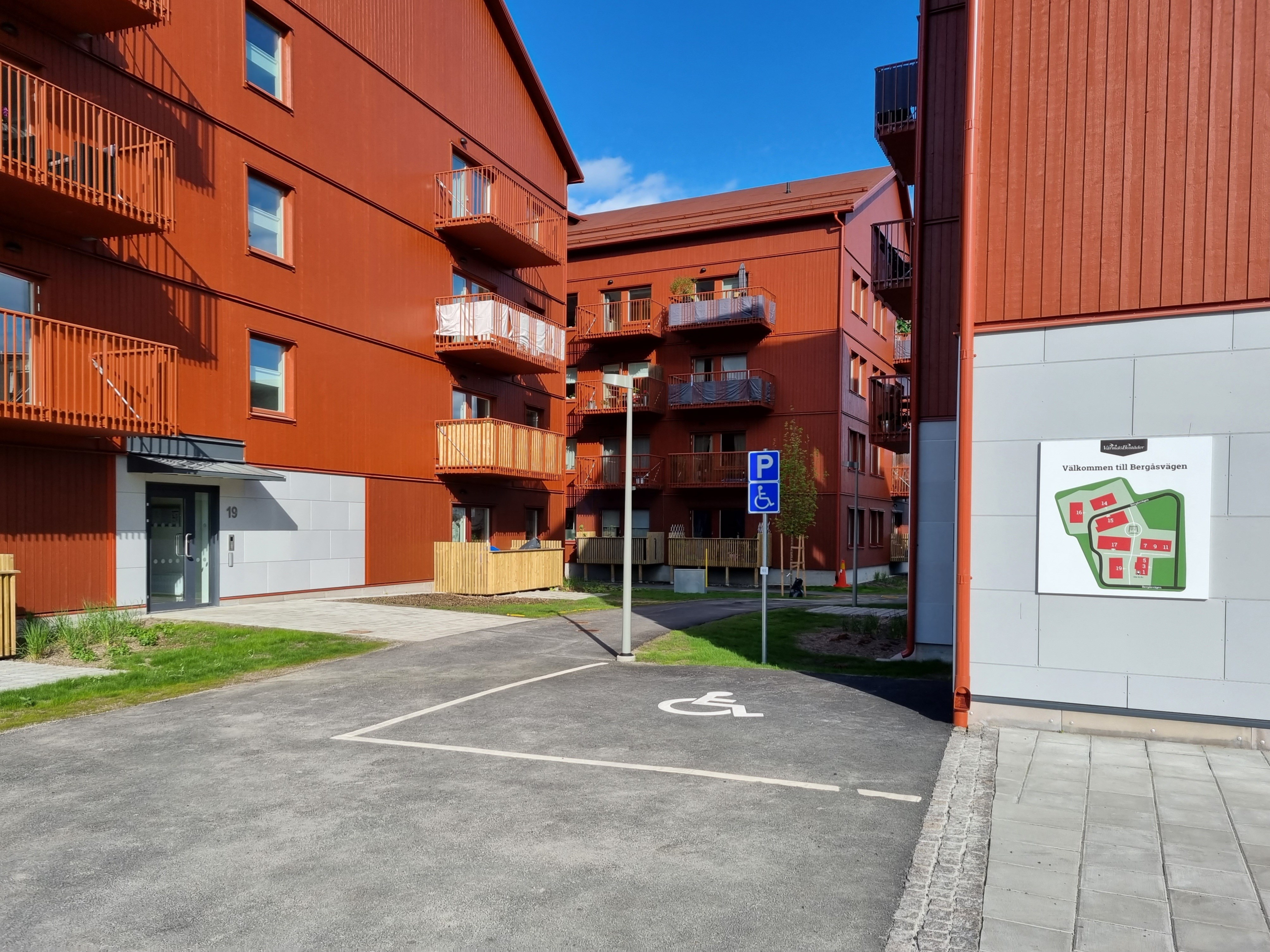 Bild på hus på Bergåsvägen i Brunn C. På gaveln av ena huset sitter en plankarta över området.