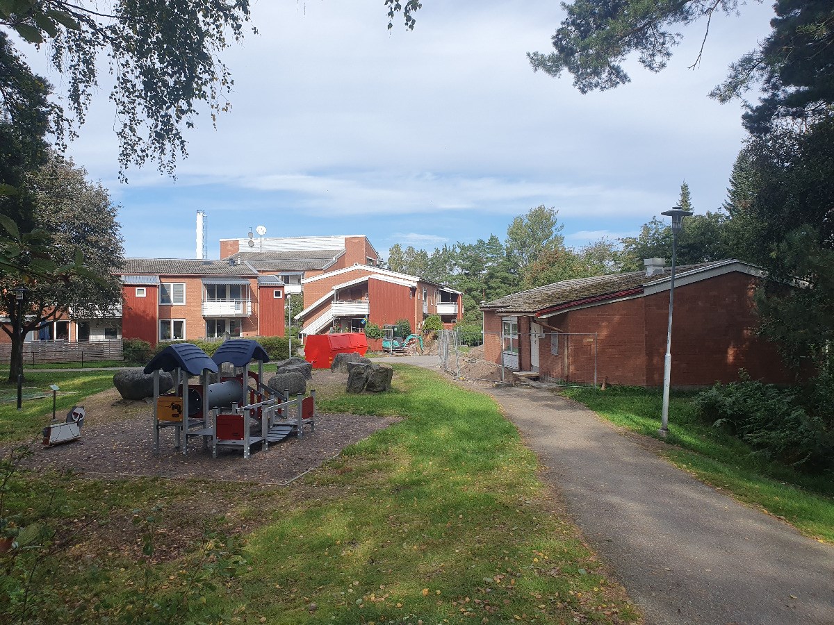 Hus som ska renoveras, lekplats utanför och befintlig gård bakom