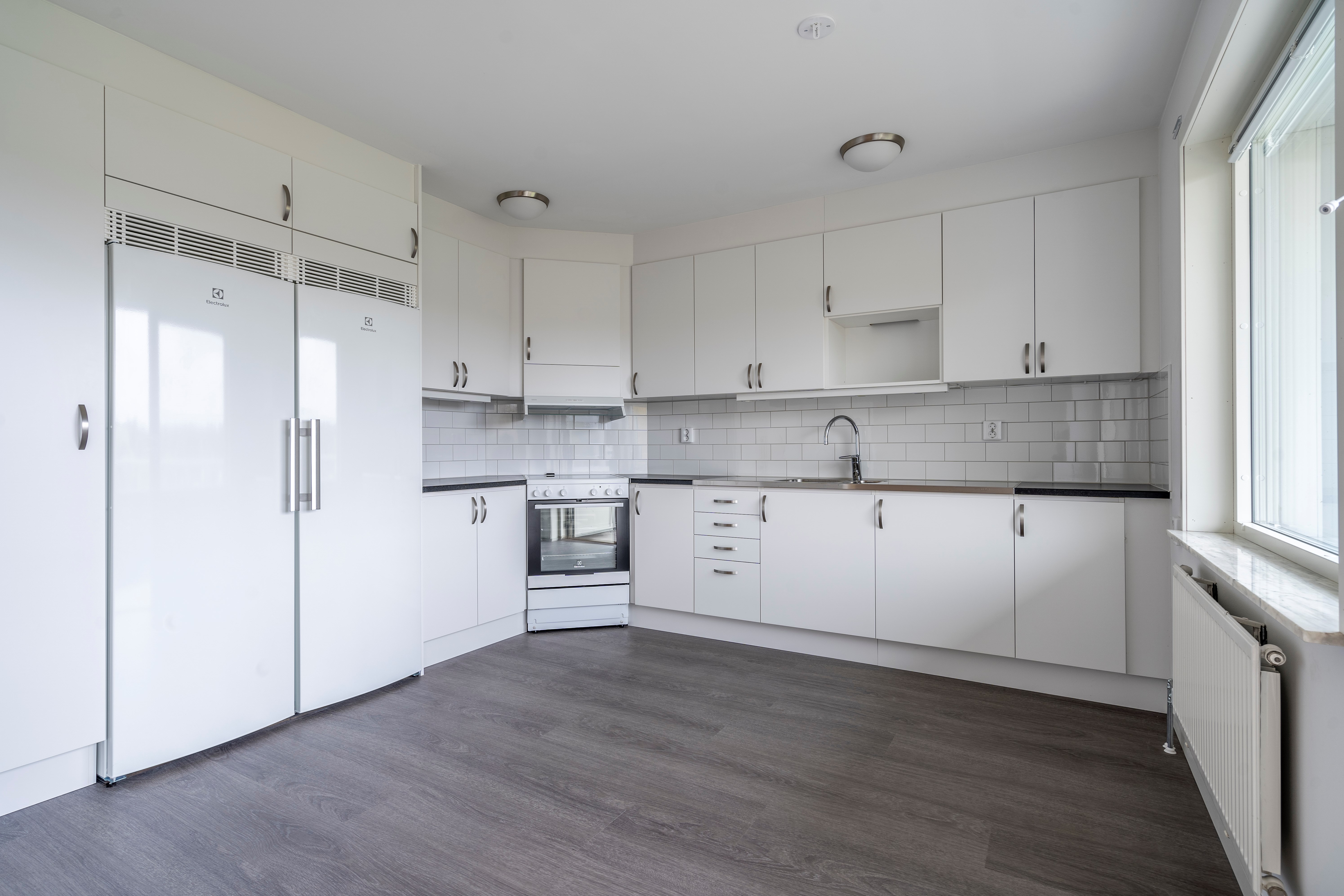 Nyrenoverat kök ,med vita luckor, nytt grått golv. 