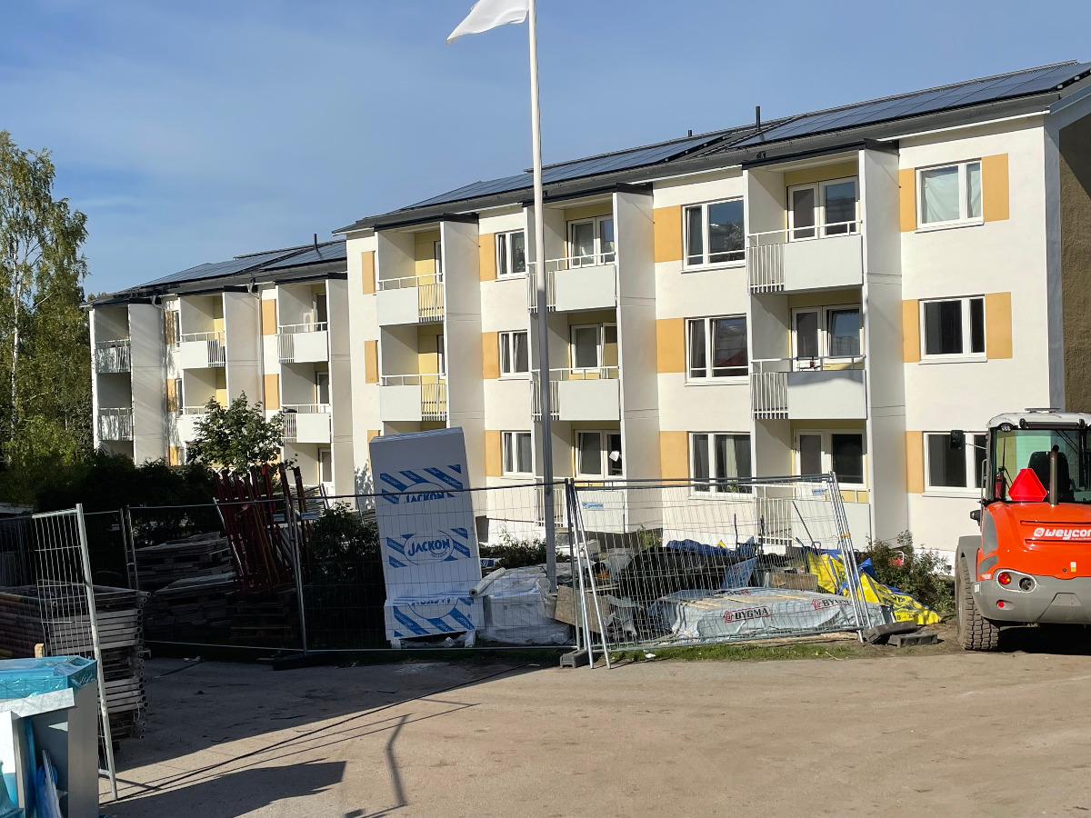 Skyttevägen renoverat hus. Byggstaket och arbetsfordon i förgrunden